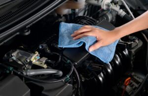 Mechanic wiping a clean engine with a blue cloth