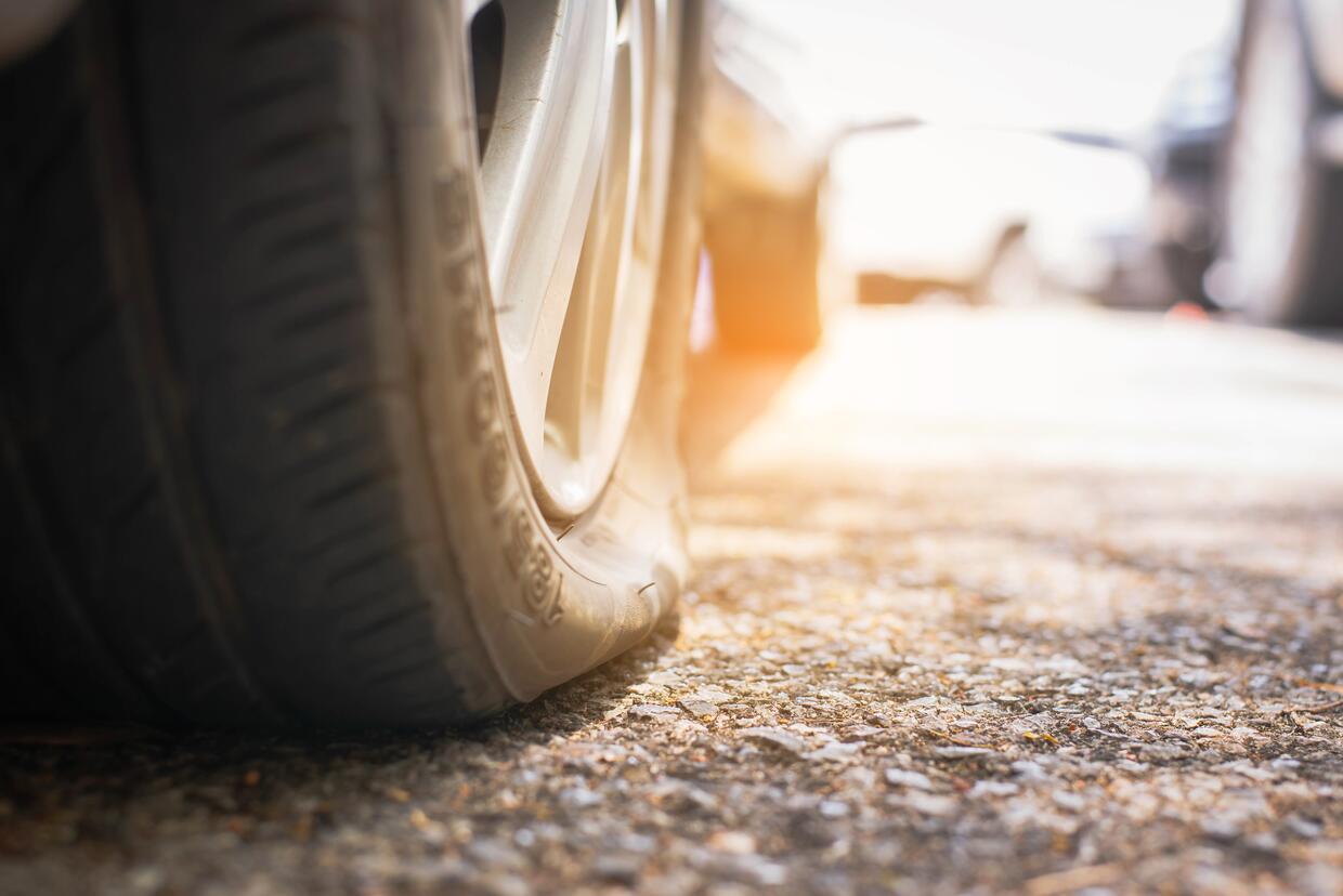 flat tire on a old car on the street waiting for sealant repairs