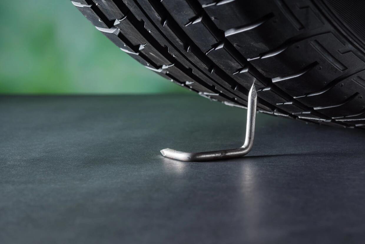 tire spikes on the ground as the tire is about to drive over it